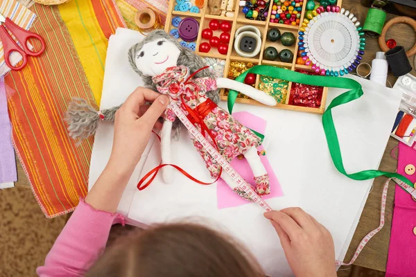 Niña cose ropa de muñeca, longitud de medición, accesorios de costura vista superior, costurera lugar de trabajo, muchos objetos para la costura, hecho a mano y artesanía — Foto de Stock