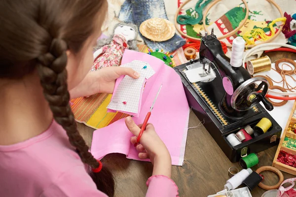 Lány sews baba ruhák, felülnézet, varrás kiegészítők felülnézet, munkahelyi varrónő, sok tárgy, kézimunka, kézműves-és kézműves — Stock Fotó