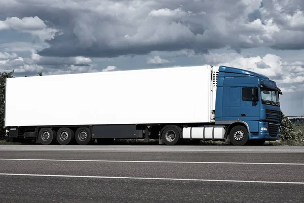 Грузовик на дороге с белым пустым контейнером, голубое небо, концепция перевозки грузов — стоковое фото
