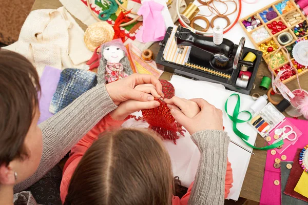 Madre insegnando figlia ragazza maglia, vista dall'alto, accessori per cucire vista dall'alto, cucitrice sul posto di lavoro, molti oggetti per cucito, fatto a mano e artigianato — Foto Stock