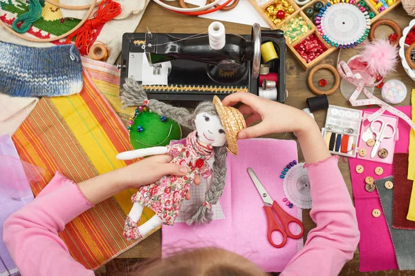 Chica cose ropa de muñeca, vista superior, accesorios de costura vista superior, costurera lugar de trabajo, muchos objetos para la costura, hecho a mano y artesanía — Foto de Stock