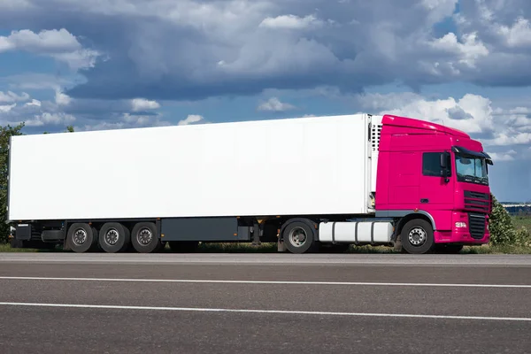 Вантажівка на дорозі з білим порожнім контейнером, блакитним небом, концепція вантажних перевезень — стокове фото