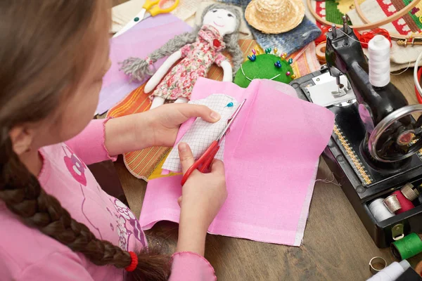 Lány sews baba ruhák, felülnézet, varrás kiegészítők felülnézet, munkahelyi varrónő, sok tárgy, kézimunka, kézműves-és kézműves — Stock Fotó