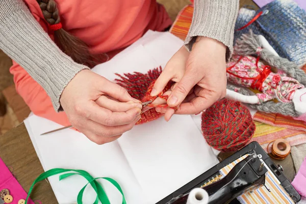 Madre insegnando figlia ragazza maglia, vista dall'alto, accessori per cucire vista dall'alto, cucitrice sul posto di lavoro, molti oggetti per cucito, fatto a mano e artigianato — Foto Stock