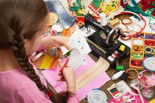 Chica cose ropa de muñeca, vista superior, accesorios de costura vista superior, costurera lugar de trabajo, muchos objetos para la costura, hecho a mano y artesanía — Foto de Stock