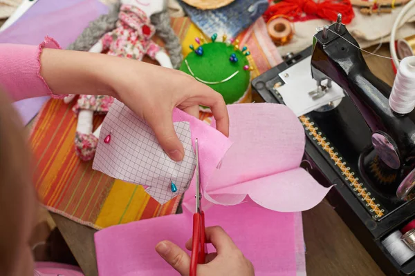 Fille coud des vêtements de poupée, vue de dessus, accessoires de couture vue de dessus, couturière lieu de travail, de nombreux objets pour la couture, fait main et artisanat — Photo