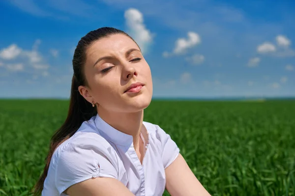 Biznes kobieta relaksujący w zielonej trawie pole odkryty pod słońcem. Piękna młoda dziewczyna ubranego w garnitur, odpoczynek, wiosnę krajobraz, jasny, słoneczny dzień — Zdjęcie stockowe