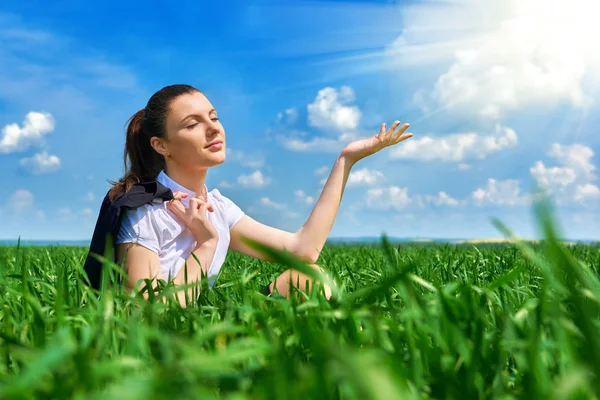 Geschäftsfrau entspannt sich im grünen Rasenfeld unter der Sonne. schönes junges Mädchen im Anzug ruht, Frühlingslandschaft, strahlend sonniger Tag — Stockfoto