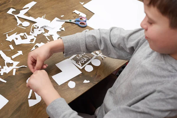 Pojken gör origami - bil och familj, barn, förälder, jag älskar dig text, ovanifrån på trä bakgrund — Stockfoto