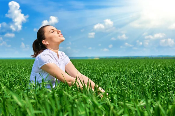 Mulher de negócios relaxando no campo de grama verde ao ar livre sob o sol. Menina bonita vestida de terno descansando, paisagem de primavera, dia ensolarado brilhante — Fotografia de Stock