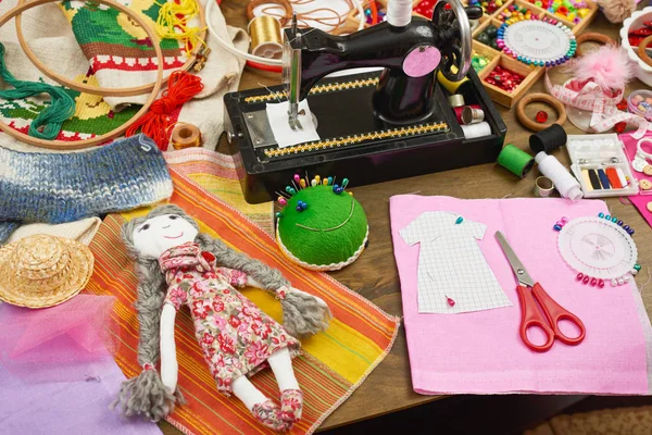 Modèle de poupée et de vêtements faits à la main, accessoires de couture vue de dessus, lieu de travail de couturière, de nombreux objets pour la couture, la broderie et l'artisanat — Photo