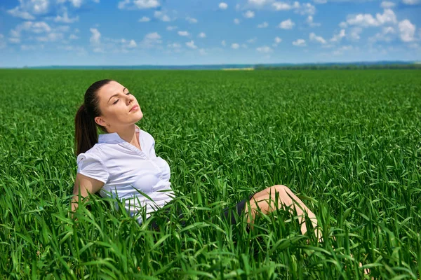 女商人，放松在室外阳光下的绿草领域。年轻漂亮的女孩穿着西装休息，春景，阳光灿烂的日子 — 图库照片