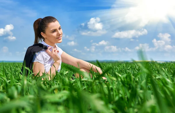 Mulher de negócios relaxando no campo de grama verde ao ar livre sob o sol. Menina bonita vestida de terno descansando, paisagem de primavera, dia ensolarado brilhante — Fotografia de Stock