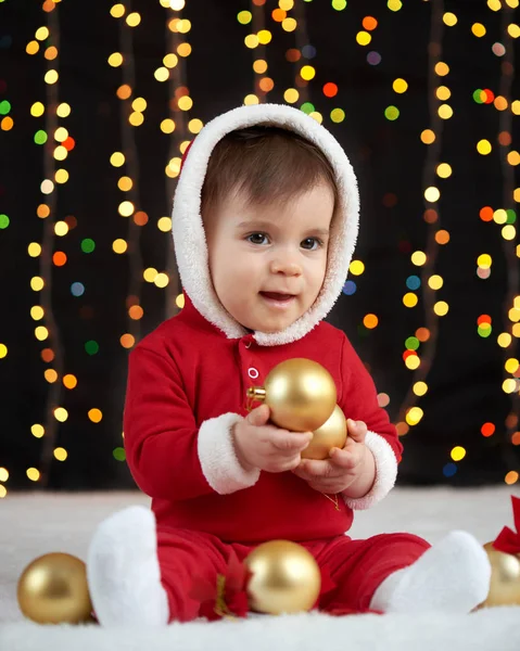 Retrato de bebé en la decoración de Navidad, vestido como Santa Claus, luces de arco sobre fondo oscuro, concepto de vacaciones de invierno —  Fotos de Stock