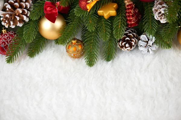 Decoración de navidad en primer plano de la rama del abeto, regalos, bola de Navidad, cono y otro objeto en piel blanca espacio en blanco, concepto de vacaciones, lugar para el texto —  Fotos de Stock