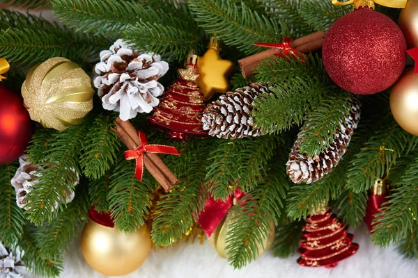 Kerstdecoratie op fir tree branch close-up, geschenken, xmas bal, kegel en andere objecten op witte lege ruimte bont, concept van de vakantie, plaats voor tekst — Stockfoto