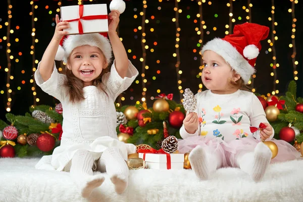 Retrato de niña en la decoración de Navidad, emociones felices, concepto de vacaciones de invierno, fondo oscuro con iluminación y luces de arco —  Fotos de Stock