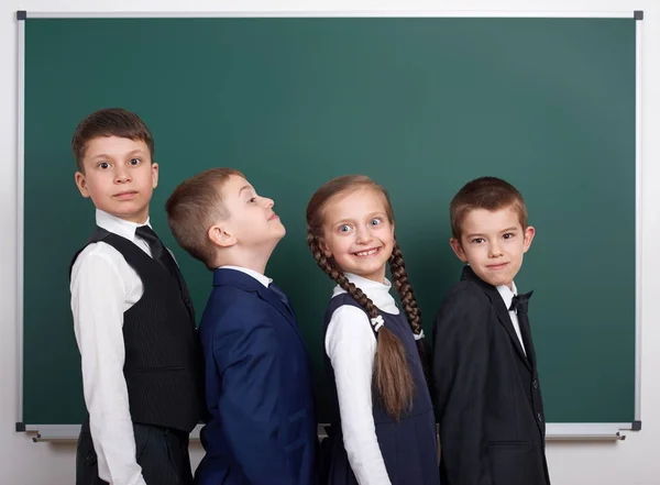 Écolier près du tableau blanc, habillé en costume noir classique, élève de groupe, concept éducatif — Photo