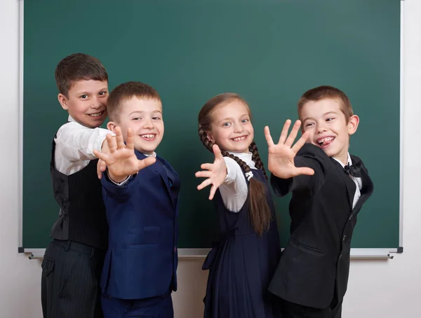 Écolier près du tableau blanc, habillé en costume noir classique, élève de groupe, concept éducatif — Photo