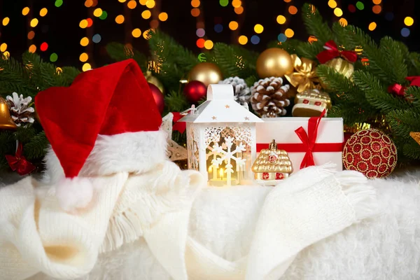 Juldekoration på vit päls med fir tree gren närbild, gåvor, xmas ball, kon och andra objekt på mörk bakgrund med ljus, vinter semester koncept — Stockfoto