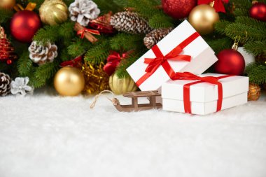 Noel dekorasyon köknar ağacı dalı closeup, ahşap kızak oyuncak, hediyeler, Noel topu, koni ve diğer nesne üzerinde beyaz boşluk kürk, tatil kavramı, yerleştirmek için metni
