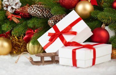 Noel dekorasyon köknar ağacı dalı closeup, ahşap kızak oyuncak, hediyeler, Noel topu, koni ve diğer nesne üzerinde beyaz boşluk kürk, tatil kavramı, yerleştirmek için metni