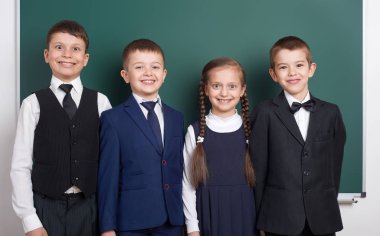 boş kara tahta arka plan, İlköğretim Okulu çocuğa giyinmiş klasik siyah takım elbise, grup öğrenci, eğitim kavramı