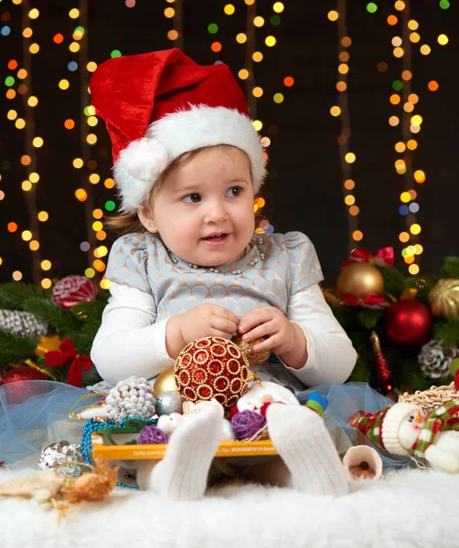 Retrato de niña en la decoración de Navidad, emociones felices, concepto de vacaciones de invierno, fondo oscuro con iluminación y luces de arco — Foto de Stock