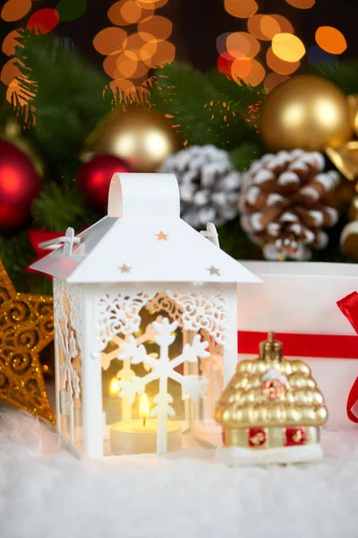 Рождественское украшение на белом мехе с веткой ели крупным планом, подарки, шар Xmas, конус и другие объекты на темном фоне с огнями, концепция зимнего отдыха — стоковое фото