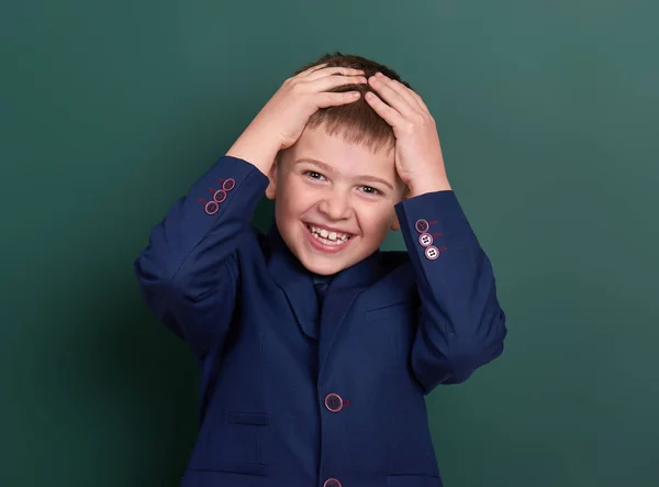 Retrato escolar muy emocional cerca de fondo de pizarra verde en blanco, vestido con traje negro clásico, un alumno, concepto de educación — Foto de Stock