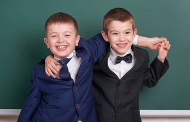iki arkadaş, boş kara tahta arka plan, İlköğretim Okulu çocuğa giyinmiş klasik siyah takım elbise, grup öğrenci, eğitim kavramı