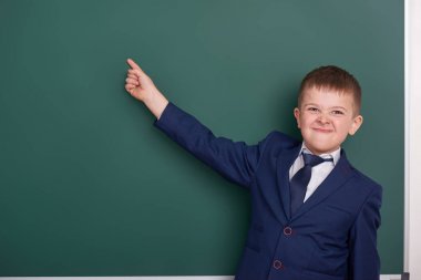 okul çocuğu işaret parmak yakınındaki boş kara tahta arka plan, giyinmiş klasik siyah takım elbise, grup öğrenci, eğitim kavramı