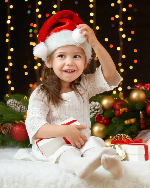 Child girl portrait in christmas decoration, happy emotions, winter holiday concept, dark background with illumination and boke lights Stock Picture