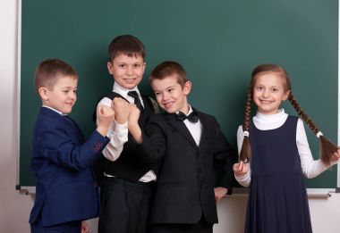 grup öğrenci boş kara tahta arka plan, yapması ve duygular, poz bir çete olarak klasik siyah takım elbise giymiş