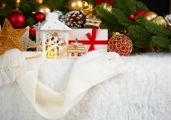 Decoração de natal em pele branca com abeto ramo de árvore closeup, presentes, bola de xmas, cone e outros objetos no fundo escuro com luzes, conceito de férias de inverno — Fotografia de Stock