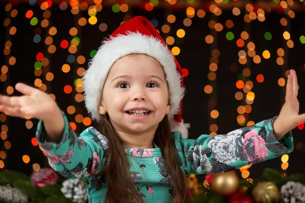 Bambino ragazza ritratto in decorazione di Natale, emozioni felici, concetto di vacanza invernale, sfondo scuro con illuminazione e luci boke — Foto Stock