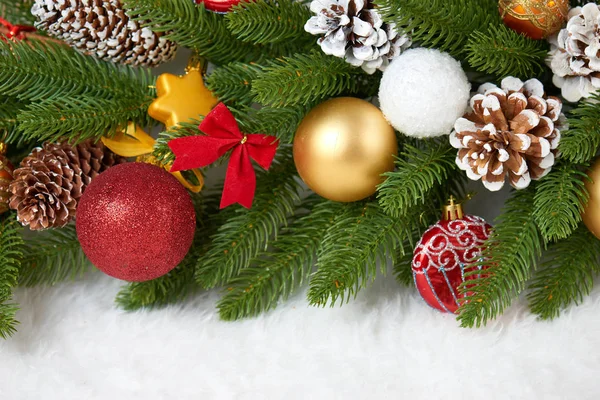 Kerstdecoratie op fir tree branch close-up, geschenken, xmas bal, kegel en andere objecten op witte lege ruimte bont, concept van de vakantie, plaats voor tekst — Stockfoto