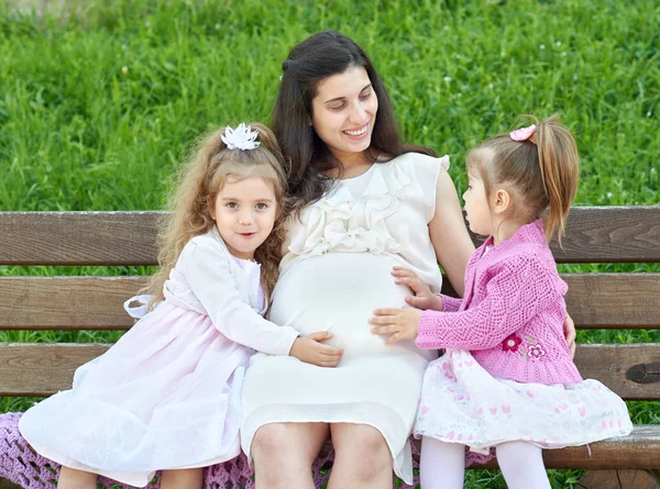 Pregnant woman and children in summer city park outdoor, happy family, bright sunny day and green grass, beautiful people portrait — Stock Photo, Image