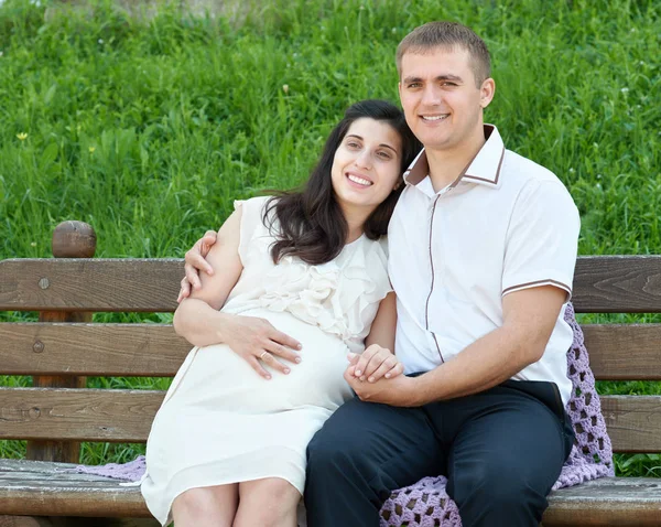 Gelukkige paar in zomer stadspark buiten, zwangere vrouw, zonnige dag en groen gras, mooie mensen portret — Stockfoto