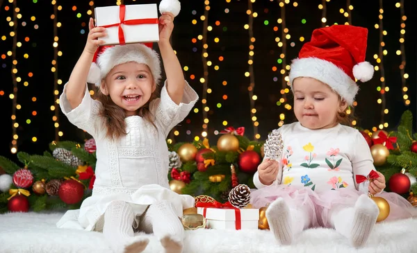 Retrato da menina criança na decoração de Natal, emoções felizes, conceito de férias de inverno, fundo escuro com iluminação e luzes boke — Fotografia de Stock