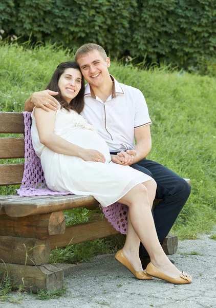 Szczęśliwa para w kobieta lato miasto park zewnątrz, w ciąży, jasny, słoneczny dzień i trawa zielona, piękny portret, żółty stonowanych — Zdjęcie stockowe