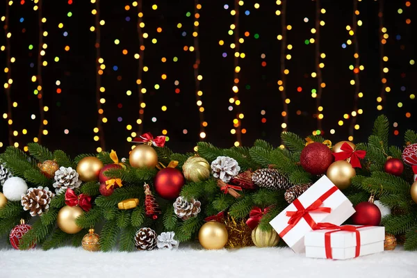 Decorazione natalizia su pelliccia bianca con primo piano ramo di abete, regali, palla di Natale, cono e altro oggetto su sfondo scuro, luci e illuminazione, concetto di vacanza invernale — Foto Stock