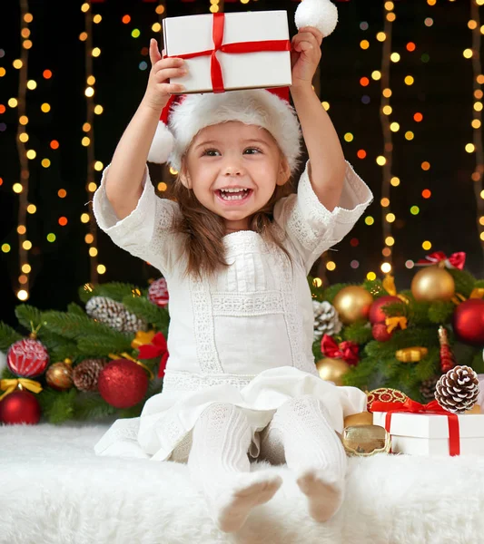 Child girl portrait in christmas decoration, happy emotions, winter holiday concept, dark background with illumination and boke lights Stock Image
