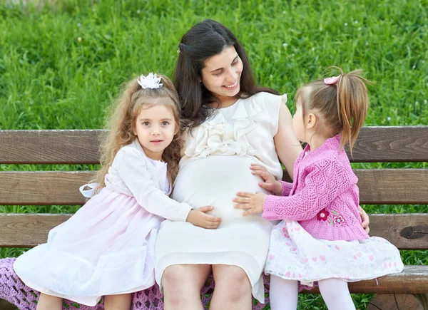 Pregnant woman and children in summer city park outdoor, happy family, bright sunny day and green grass, beautiful people portrait — Stock Photo, Image