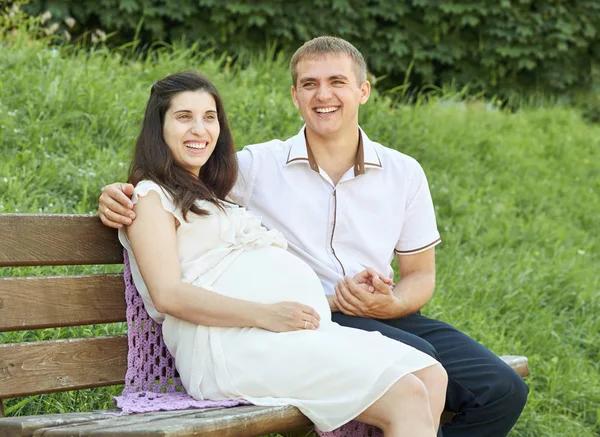 Šťastný pár v létě city parku venkovní, těhotná žena, jasný slunečný den a zelené trávy, krásní lidé portrét, žluté laděných — Stock fotografie