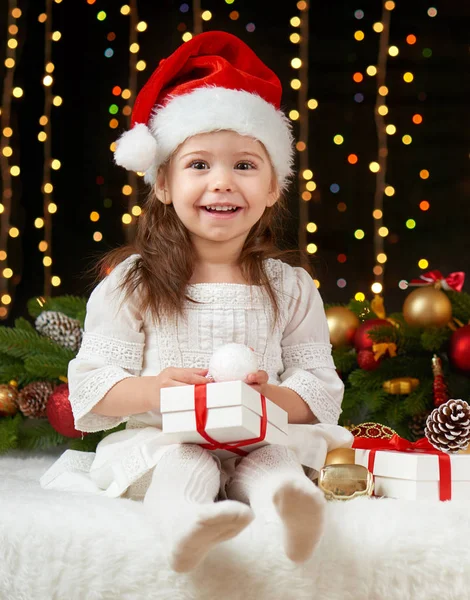 Retrato da menina criança na decoração de Natal, emoções felizes, conceito de férias de inverno, fundo escuro com iluminação e luzes boke — Fotografia de Stock