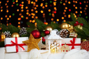 köknar ağacı dalı closeup, hediyeler, Noel top, koni ve diğer nesne ışıklı, kış tatil kavramı koyu arka plan üzerinde beyaz kürk Noel dekorasyon