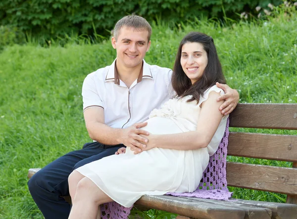 Gelukkige paar in zomer stadspark buiten, zwangere vrouw, zonnige dag en groen gras, mooie mensen portret — Stockfoto