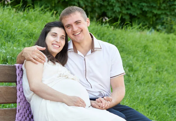 Šťastný pár v létě městský park venkovní, těhotná žena, jasný slunečný den a zelené trávy, krásných lidí portrét — Stock fotografie