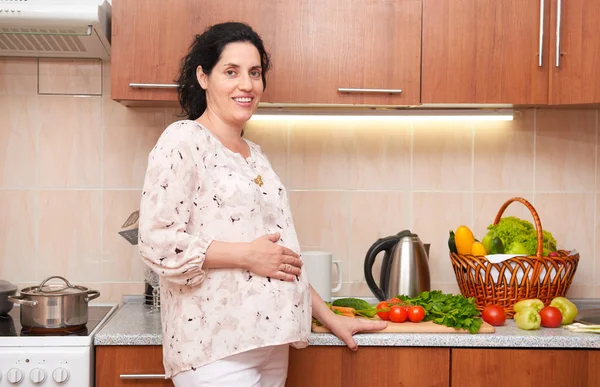 Těhotná žena v kuchyni interiéru s čerstvého ovoce a zeleniny, koncept zdravé potraviny — Stock fotografie
